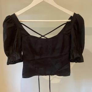 svart topp med knyte i ryggen - svart topp med knyte i ryggen, fick tröjan av en kompis och då va lappen redan avklipp så är osäker vart den kommer i från. dne är i typ silke material och är jätte skön❤️