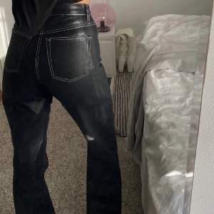 Coola glansiga svarta jeans med vita sömmar. Rak passform!! 