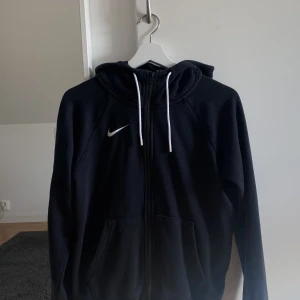 Nike hoodie - Svart nike luvtröja i storlek XS från Nike! Tightare i modellen och har en dragkedja hela vägen upp, använd fåtal gånger därav fint skick!💛