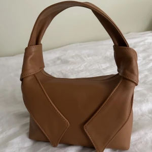 & Other Stories handväska - En liten, brun väska från & Other Stories (20 X 12 cm ISH). Endast använd en gång, så i superbra skick. Nypris ca 800 kr. Tveka inte att höra av er för fler frågor eller bilder 🤎