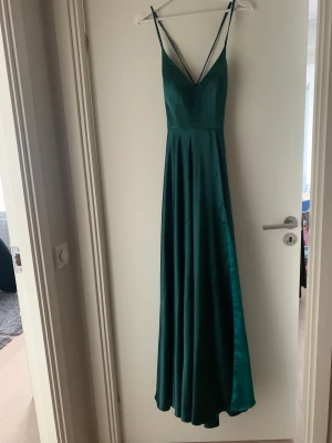 Coctailklänning/Balklänning - Oanvänd balklänning som passar till andra even också. Inköpt för 4800kr. Säljer för 3000kr ink frakt. Klänningen är special sydd efter min längd (173cm) och har en slit längst det vänstra benet.  Knytning i ryggen så att klänningens överdel är justerbar.