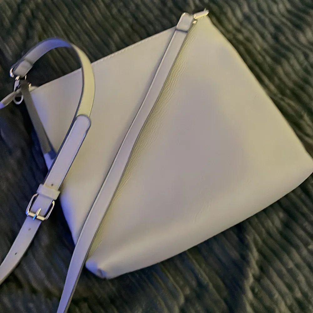 Säljer en riktigt fin mellan modell väska märke Orsay färg ljusgrå och mörkgrå med justerbar axelrem i mjukt material . Väskor.