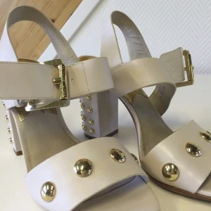 Michael kors skor  - Super snygg sko från Michael kors. Beige med guld detaljer. Använd vid 2 tillfällen . Klack höjd 9 cm