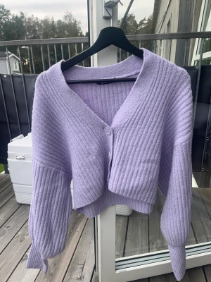 Lila stickad kofta - Fint skick men använd. Väldigt fin färg och kliar aldrig. Ser även väldigt välgjord ut