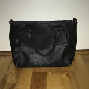 En svart fuskläder handväska från nicole, den är använd men har inga jättemärkvärdiga märken förutom att färgen har släppt lite på under hörnen.