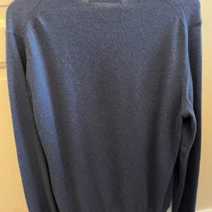 En stickad blå tröja i fin ull av märket Maglia Studio. Nästintill oanvänd, därav inga fläckar, hål eller dylikt. Den är i storlek large och köpt för 1400.