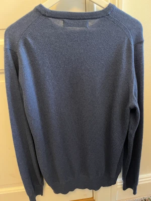 Stickad tröja Maglia Studio - En stickad blå tröja i fin ull av märket Maglia Studio. Nästintill oanvänd, därav inga fläckar, hål eller dylikt. Den är i storlek large och köpt för 1400.