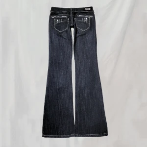 Lågmidjade jeans - Midja:74 innerben:85 Låga jeans med detaljerade bakfickor och rhinstones. Står storlek 38 men uppskattar passa mer kring en S. Lite mjukare i materialet. Hittar inga uppenbara defekter, överlag mycket fint skick!🤍