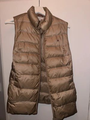 TOMMY HILFIGER VÄST - Säljer min beiga Tommy Hilfiger väst som är i strl S/38.  Använd ett par enstaka gånger så skicket är som ny! Inköpt på Zalando för 3500kr!  !FINNS I DJURFRITT & RÖKFRITT HEM!
