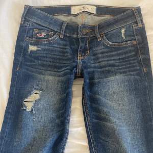 Säljer dessa sjukt snygga lågmidjade jeans från hollister med hål i. De är slim/baggy. Innerbenslängd: 75 cm ytterbenslängd: 94 cm 💕