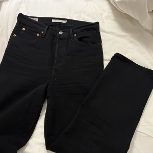 Levi’s jeans svarta - Ett par svarta levi’s Jeans i modellen ribcage  Tvättade en gång  Strl 28 De har en tightare passform upptill med straight passform i benen och lite vidare  Nypris: 1300  