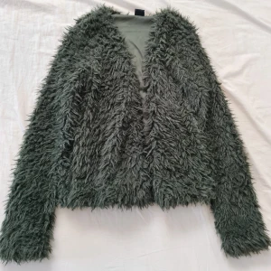 Grön fluffig kofta - En fluffig, pälsig kofta i en mycket snygg mörkgrön färg. Från Gina Tricot, använd ett fåtal gånger, därmed är den i mycket fint skick 