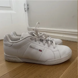 Classic Reebok skor - Säljer mina vita classic Reebok skor då de inte kommer till användning. Lite smuts på sulan och lite på sidan av skorna som syns på bilden men det går säkert att få bort. Storlek 39