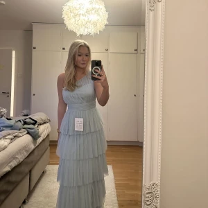 Balklänning - Säljer denna kläning då jag missa returnerings datumet och jag hittat en annan. Super fin ljusblå volang kläning som är one sholder⭐️Alla lappar/taggar sitter kvar och den är aldrig använd utan endast provat den🩷 Skriv privat för fler bilder