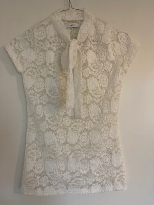 Jättefin spetstopp med knytning  - Supersöt spetstopp med knytdetalj vid halsen, lite polohals. Aldrig använt.