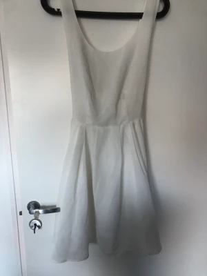 Klänning  - Klänning med öppen rygg. Finns dragkedja och band för en rosett i ryggen. Använd 2 gånger