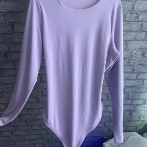 Lila bodysuit, med string - Sitter som en L, aldrig kommit till bra använing aldrig varit så kär i lila men blev ett spontanköp som jag ångrar nu i efterhand men kommer säkert sitta toppen på någon annan💕tillägget man ser på baksidan av bodyn är ett skydd så att man slipper ha BH:)