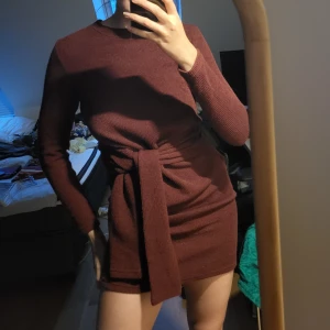 Klänning med knytmidja - Perfekta julklänningen! En vinröd klänning i tjockare stickat tyg, mycket stretchig men håller formen! Knyts i midjan är väldigt smickrande för kroppen! Storlek S från Bikbok, mycket fint skick. Svarar på alla frågor ❤️‍🔥