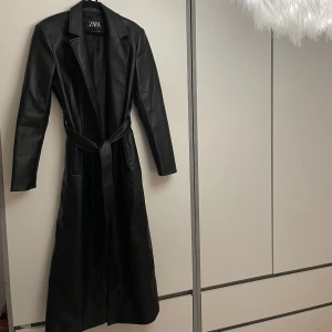 Kappa - Säljer denna fina kappa i fusk läder från Zara. Köpte den i maj och den är helt oanvänd. Köpte den för 860kr 