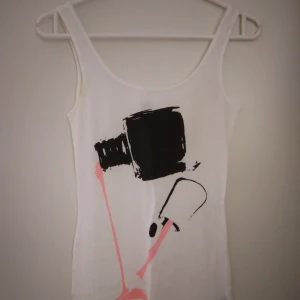 Vitt linne med tryck. Strlk: 32 / XS. Bomull. Felfri. - Vitt linne med makeup/nagellack-tryck. Strlk: 32 / XS. Bomull. Felfri.