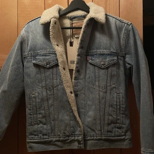 Levis Jeansjacka  - Superfin och skön jeansjacka med Teddy tyg invändigt, säljes då den inte kommit till användning av mig, helt oanvänd med lapparna kvar, storlek xxs men passar xs (Nypris ca 1500kr)