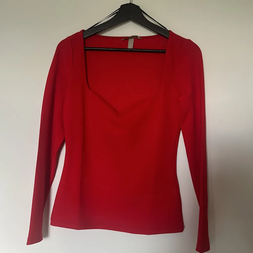 Säljer denna långärmade röda tröja med hjärtformad v-ringning och som har bekvämt material. . Blusar.