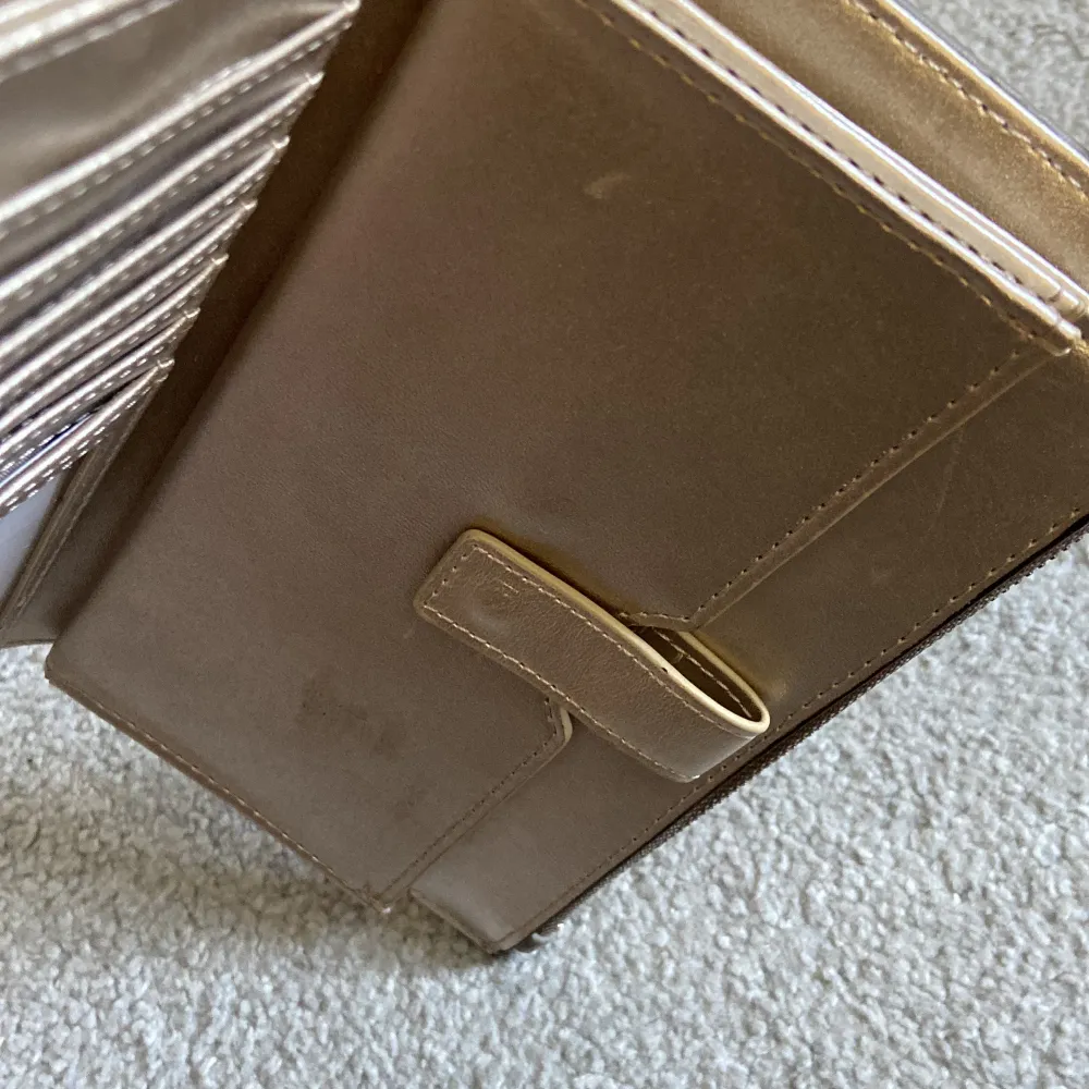 Guess plånbok/väska i en lung grå färg, med guess mönster över hela plånboken. Den är såklart äkta och köpt via Zalando. Qr kod finns. Använt 3-4 gånger. På ena sidan ser man lite slitning/repor på skinnet. Annars väldigt fräsch och fin. Nytt pris 899kr.. Väskor.