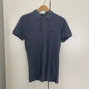 Armani jeans polo i blått, bra skick. Skulle säga att den passar mer som en M. 