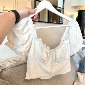 T-shirt Blus - Säljer en vit t-shirt blus i något kortare modell.  Tröjan är i ett mycket fint skick.  Färg: Vit Storlek: M