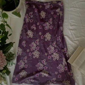 Lila maxi kjol - Lila maxi kjol med blom mönster. Använd en gång. Bra skick. Går att stretcha ut. 