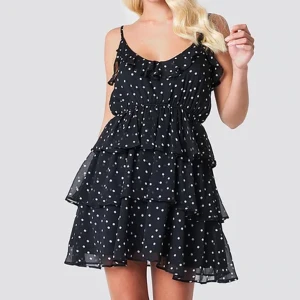 Prickig klänning med låg rygg - Söt prickig klänning från Linn Ahlborg x NA-KD. Justerbara axelband, volanger och djup rygg. Använd fåtal ggr. Storlek 36. 