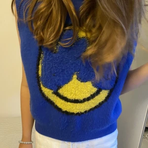 Blå Smiley Väst - Säljer min blåa stickade smiley väst i storlek S från Cider!! Västen har en smiley både fram och bak😄 Den är lite nopprig men det är inget man tänker på! 💘💘