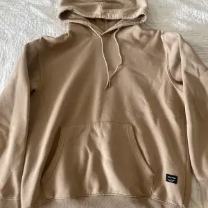 En beige/ljusbrun hoodie från Jack & Jones som inte kommer till användning. Den har en jätte liten fläck som man kan se på sista bilden. 