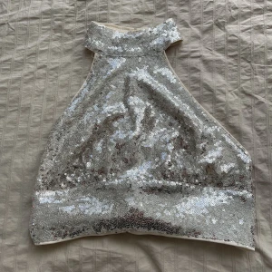 Glittrig topp - Jätte fin glittrig topp med öppen rygg, passar perfekt för nyår eller andra festligheter. Endast använd en gång. Storlek Xs passar även som S. 