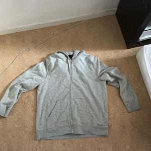 Grå zip hoodie - En grå zip hoodie som är för stor för mig.
