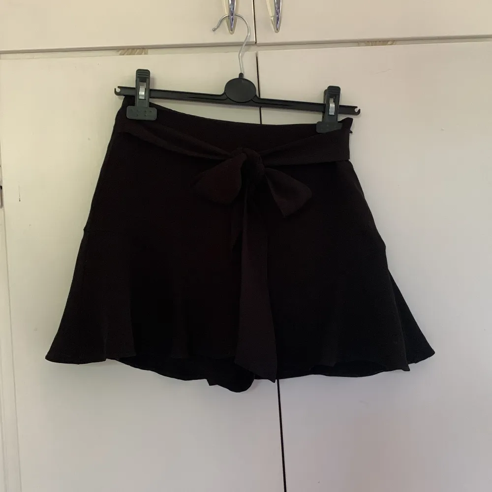 Söt svart kjol från Zara med smarta inbyggda shorts och knytning i midjan!💝Första bilden lånad!. Kjolar.