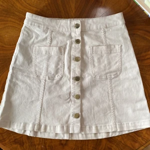 Vit jeanskjol  - Vit jeanskjol i 98% bomull från H&M divided! Knappt använd men färgen på guld knapparna har slitits av lite