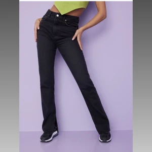 Jeans  - Slutsålda svarta jeans med slits från Nelly.