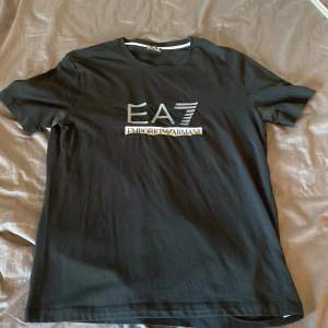 Svart T-shirt från armani, EA7 trycket har daragit ihop sig lite efter tvättn, och den har deo fläckar på båda armarna! Storlek M