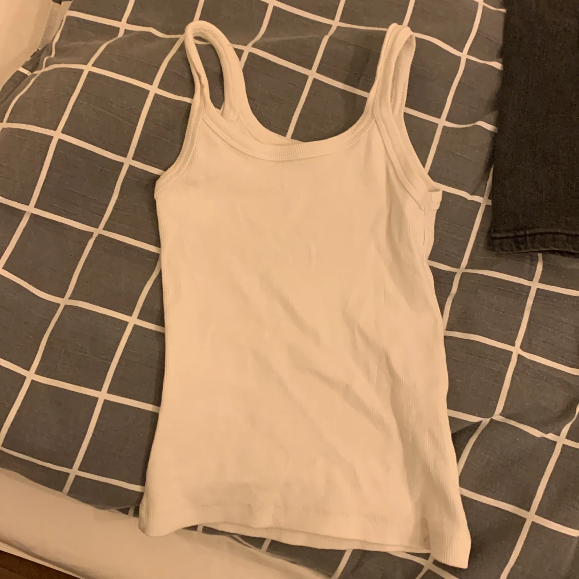 Vitt linne, lite ribbat men syns knappt. För liten för mig.