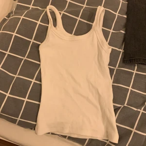 Vitt linne, lite ribbat men syns knappt. För liten för mig. - I bra skicka, inte använts så många gånger. Den är ganska tajt men väldigt bra att ha tex under en stickad tröja. 