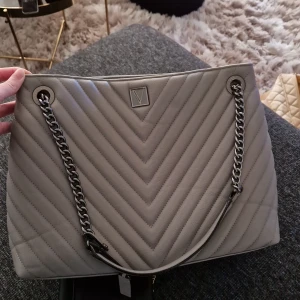 Väska från victoria secret  - Grå/beige väska från victoria secret, med kedja, mycket fint skick 