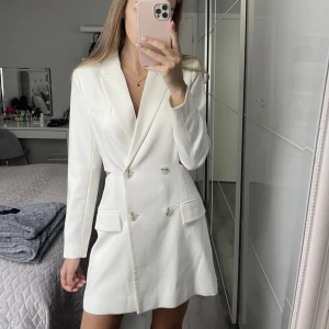 En vit kavaj klänning  - Säljer en vit kavaj klänning som har använts en gång på min student. Den är som ny, har inga defekter, köpted från zalando stradivarius är i storlek S.