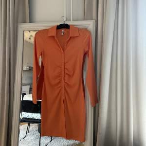 Orange klänning från Nelly, storlek S. Använd 1 gång. 
