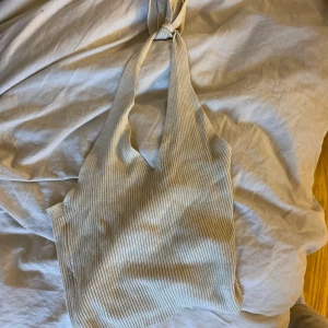 Beige topp - Beige topp med knyte i nacken från Åhlens Outlet, aldrig använd.