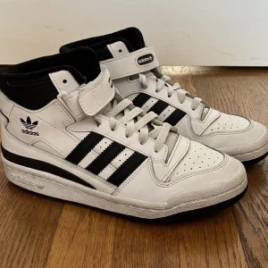 Adidas Forum Mid - säljer mina forums då dem inte kommer till användning. har använts fåtal gånger, finns en crease på ena skon men ändå bra skick. nypris 1200 kr, pris kan diskuteras. skorna tvättas innan dem skickas :)