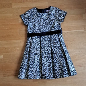 Leopardmönstrad klänning - Leopardmönstrad finklänning i väldigt bra skick. Svarta bandet ingår.