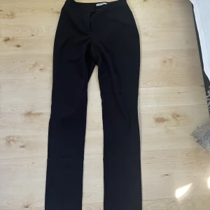 Kostymbyxor m slits - Svarta raka kostymbyxor med slits framme vid foten. 