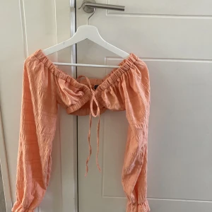 Topp - Jättefin topp i en superfin orange nyans! Jättefina detaljer i tyget och väldigt skön och passar perfekt inför sommaren. Både att klä upp och klä ner. Man knyter den själv framtill😍😍