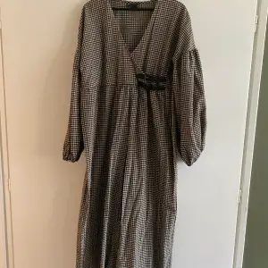 Super luftig och oversized byxdress i Gingham. Något croppad i ben och armar med dekorativa spännen och omlottdesign på överdelen. Aldrig använd, hann dock tycka loss taggarna! Super fin och tunn. Ge den, den kärleken som jag aldrig hann 💔🥲